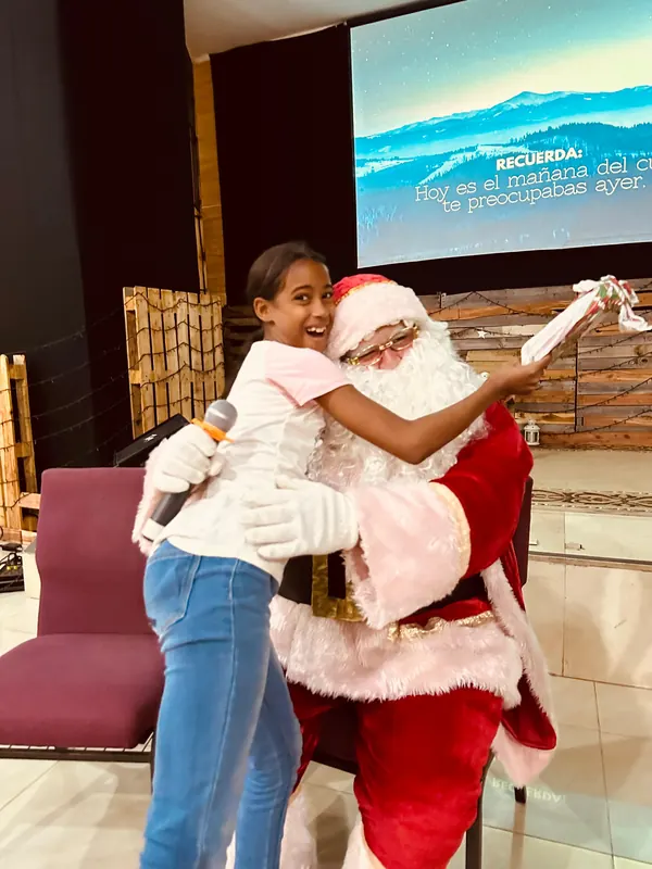 Una niña abraza a Santa Claus mientras recibe su regalo, durante una fiesta de Navidad de la fundación.