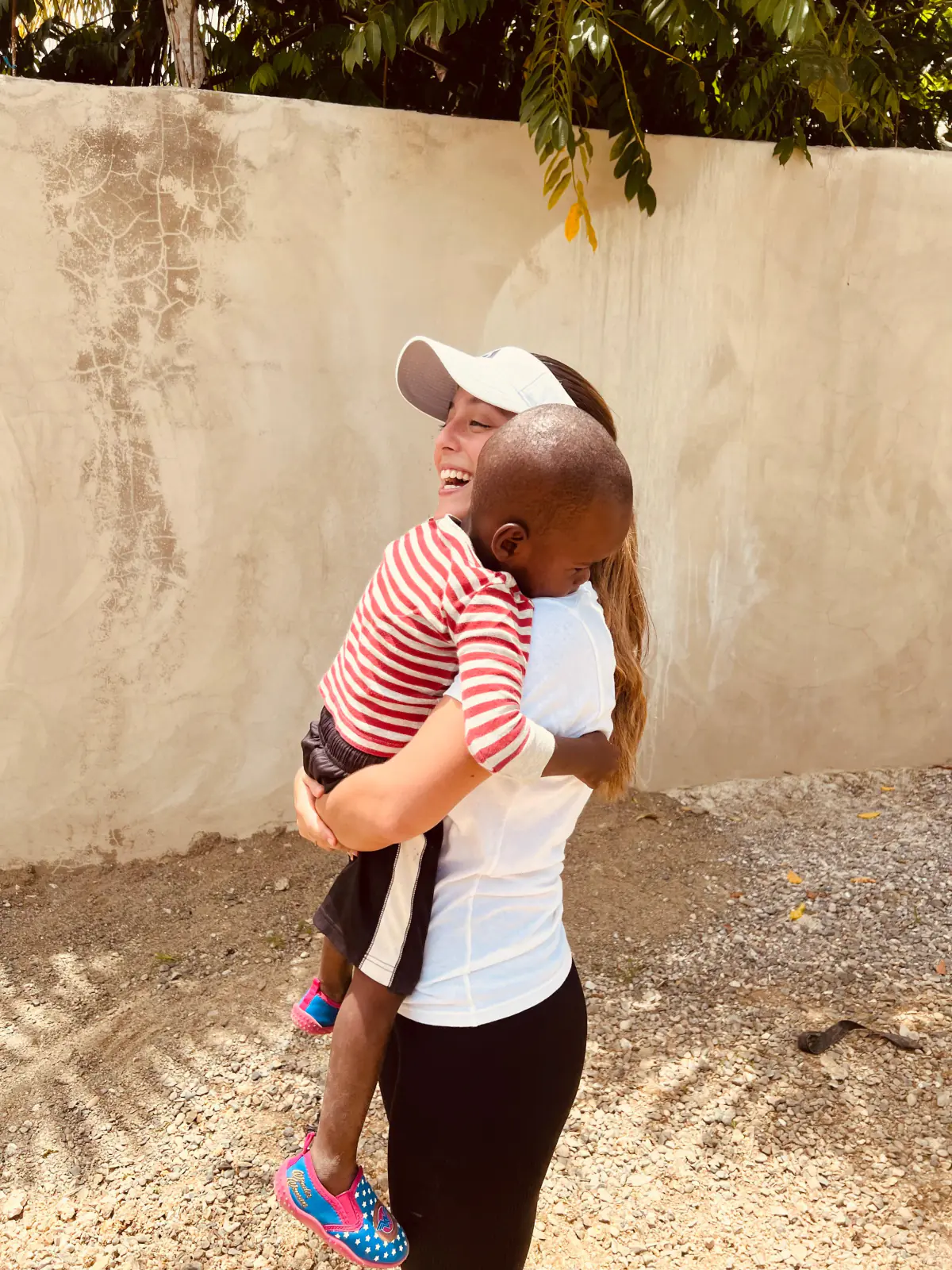 Luigiana D’Antonio, fundadora de Ágape, ríe mientras carga en brazos a un niño durante una jornada de la fundación.